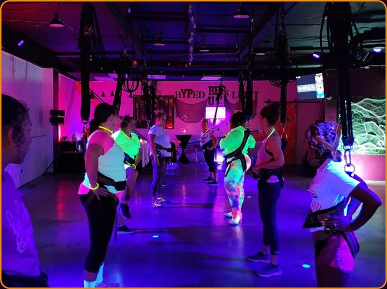 A Bungee Up flyer mid-bounce under the studio’s neon glow lights
