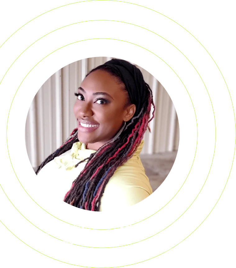 Kaela Jacobs, founder and Executive Head Fly Coach of Bungee Up, smiling over her shoulder with her locs styled in red and black