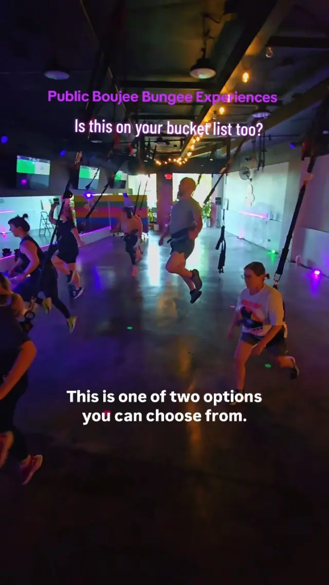 Guests at a public Boujee Bungee Experience bouncing at their stations in a neon-lit studio